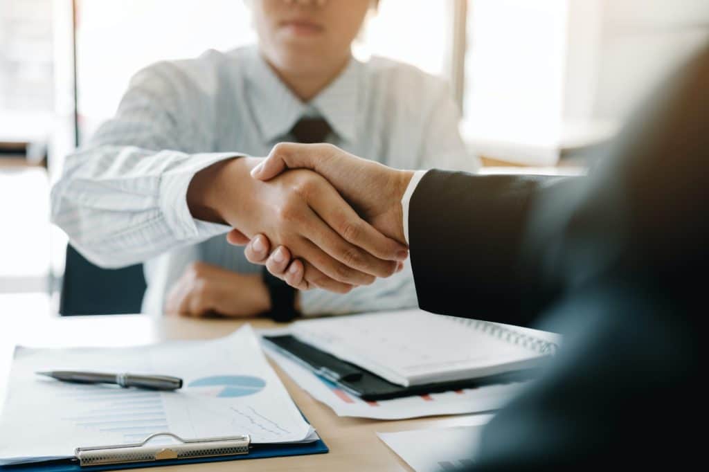 Businessman shaking hands with customer in office.